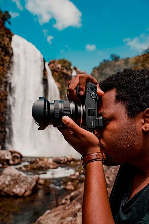 Persona fotografiando un paisaje con una cámara Sony y el nuevo objetivo de Tamron.