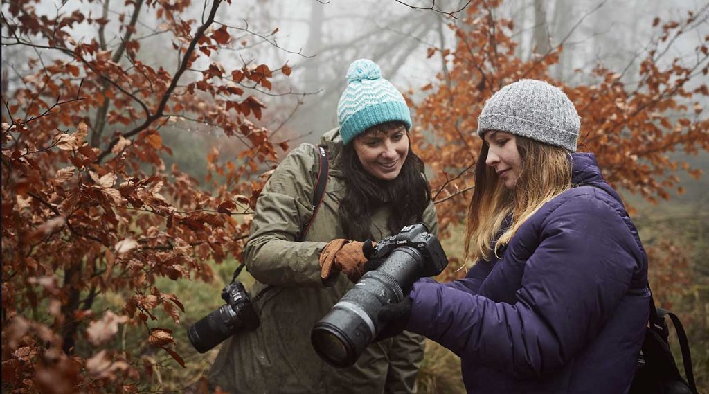 Dos fotógrafas que participan en los cursos gratuitos de Canon compartiendo impresiones.