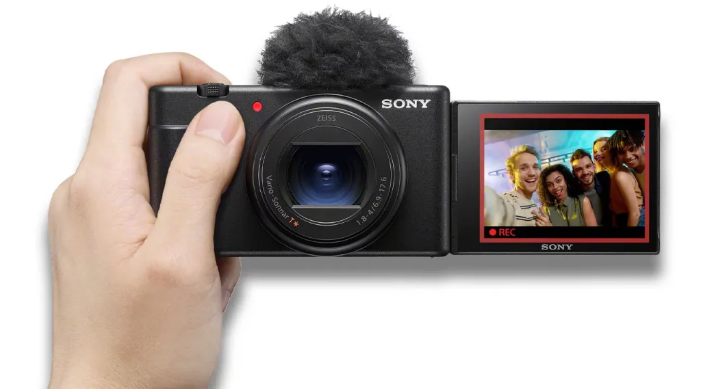 La cámara ZV-1 II de Sony con paravientos y la pantalla desplegada para la realización de un selfi.